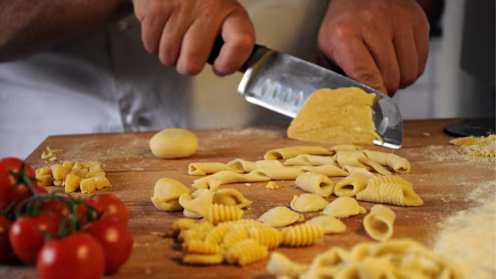 Partecipanti che lavorano l'impasto della pasta fresca con le mani durante la lezione