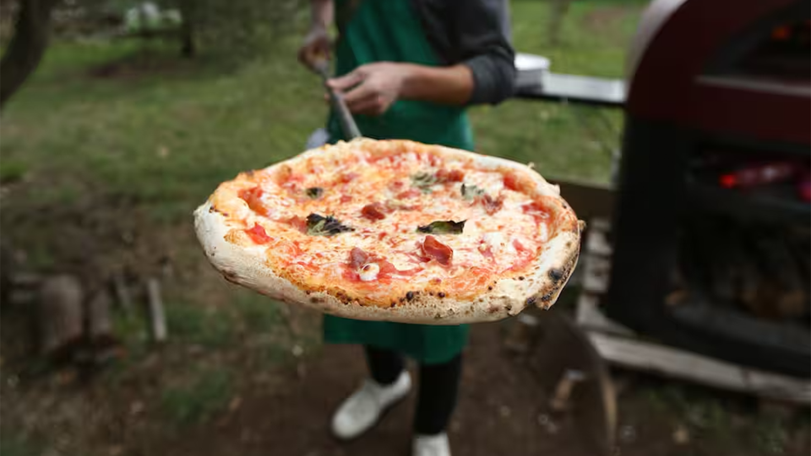 Pizza napoletana cotta nel forno a legna durante il corso di pizza tradizionale italiana