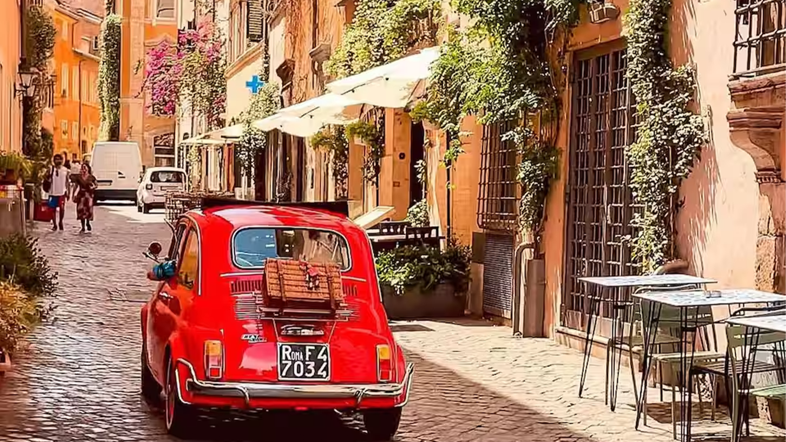 Fiat 500 d'epoca che attraversa i vicoli caratteristici di Trastevere a Roma
